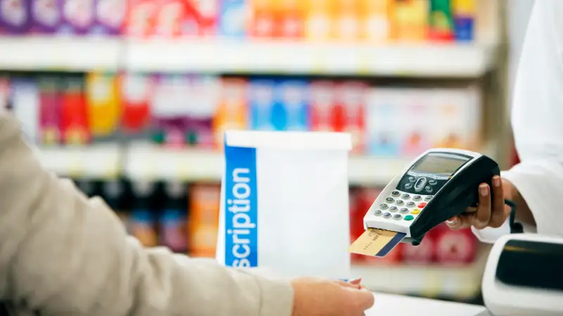 person paying for prescription at pharmacy