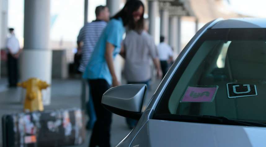 Uber and Lyft cars drop off passengers at the Bradley terminal at LAX, October 20, 2015.