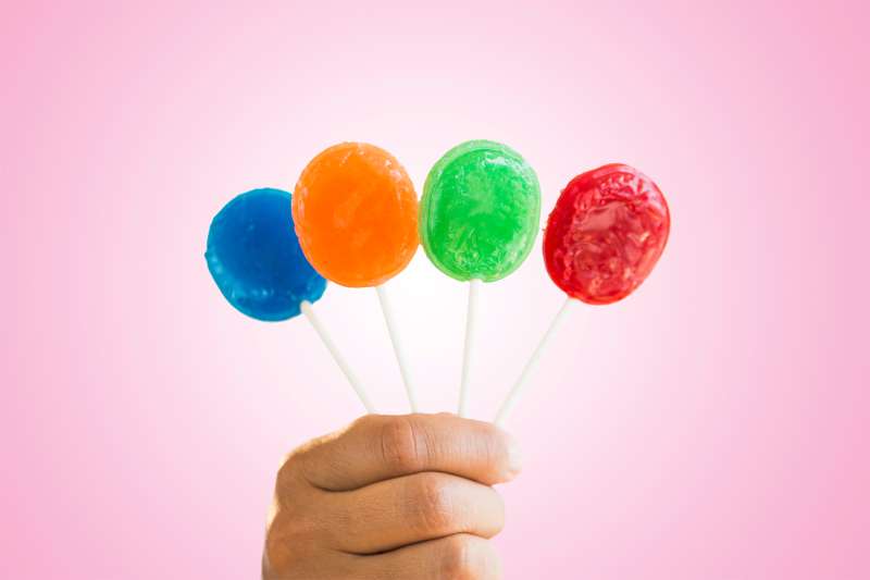 hand holding colored lollipops
