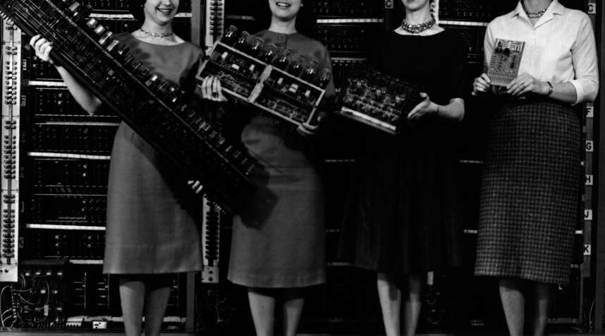 Women holding the first four computer circuit boards.