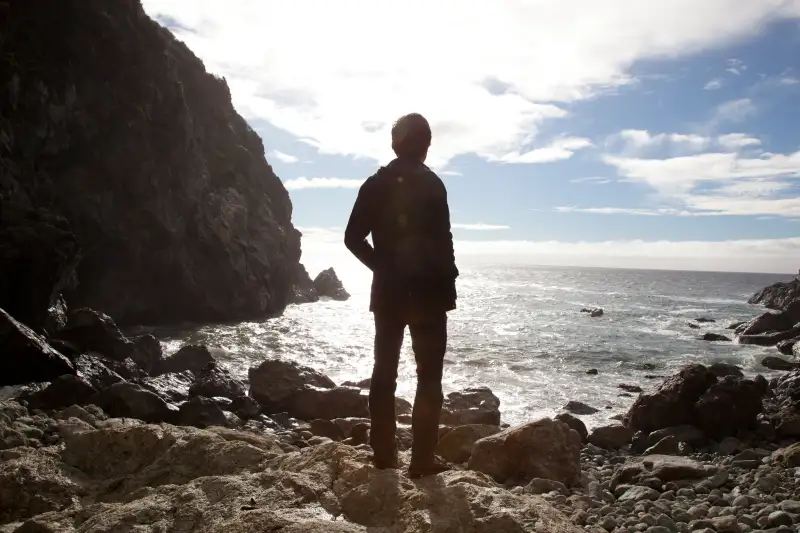 man on beach looking at view