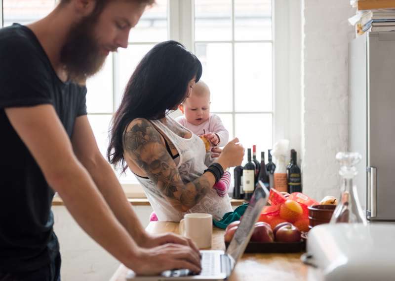 Young Family With Newborn Baby In Their Kitchen