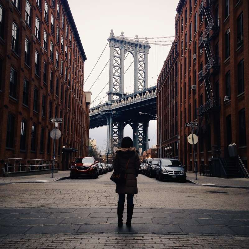 Rear View Of Woman Standing In Front Of Manhattan Bridge