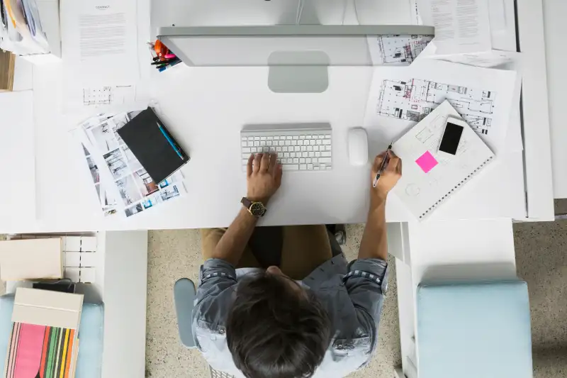 Overhead view architect working at computer