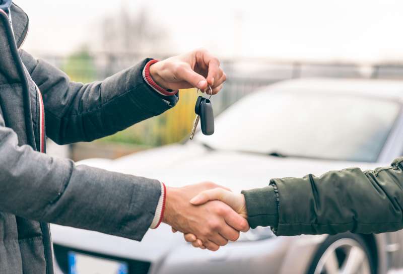 Two people reaching an agreement about a car sale