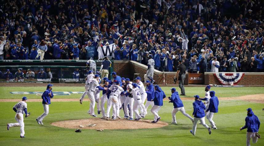 Chicago Cubs players and staff celebrate winning the NLCS after defeating the Los Angeles Dodgers in action during the 9th inning of game six of the National League Championship Series between the Los Angeles Dodgers and the Chicago Cubs at Wrigley Field.