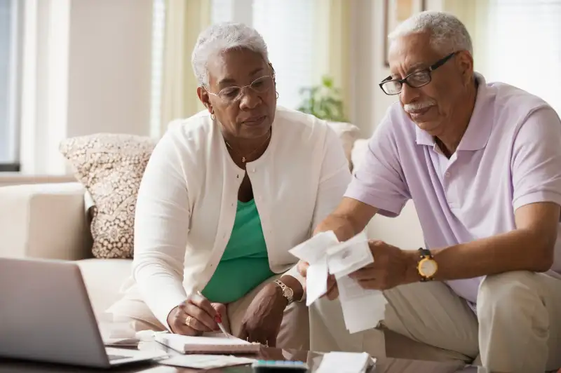 Elderly couple paying bills with laptop