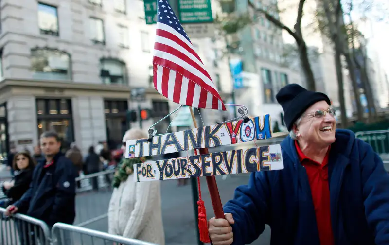 A man holds up a Thank You sign before the Veterans Day Parade in New York November 11, 2012.