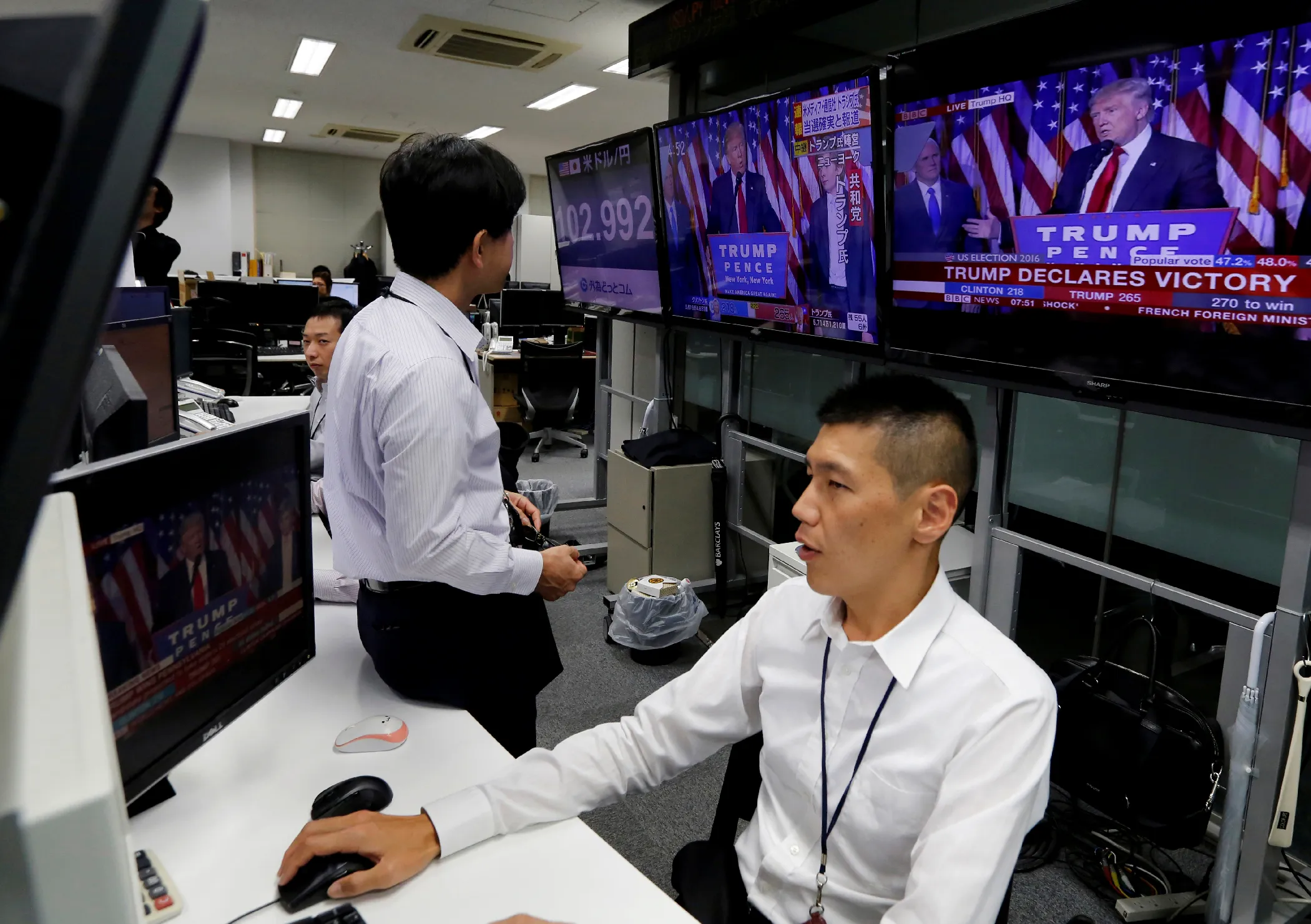 In Japan, traders working a foreign exchange desk watch U.S. election results. The Nikkei index fell more than 900 points as Trump's win became real. 