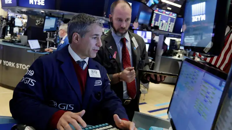 Trader Anthony RInaldi, left, works on the floor of the New York Stock Exchange, November 7, 2016.