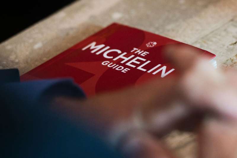 Michael Ellis from Michelin poses with the Michelin guide book at a restaurant in Washington, DC on October 12, 2016.