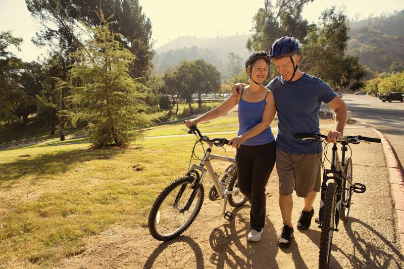 Mature couple in park with bikes.