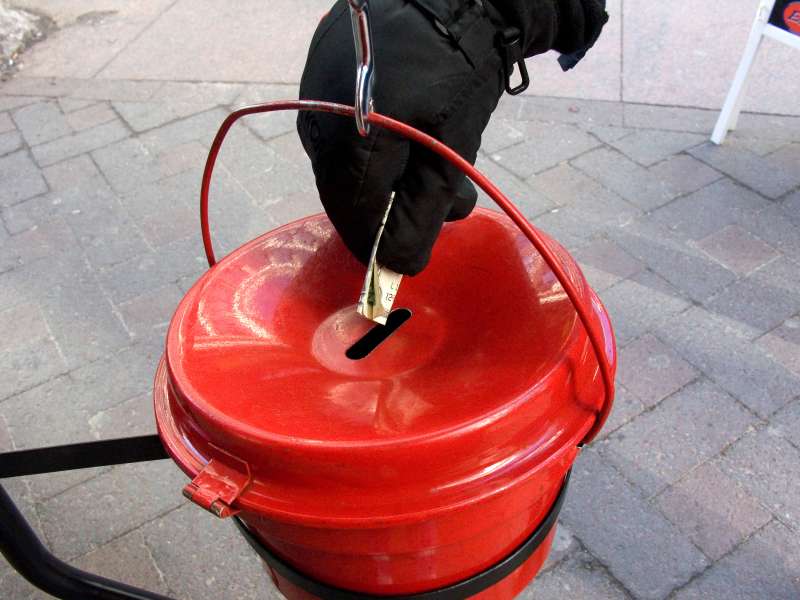 Person putting money into a Salvation Army kettle.