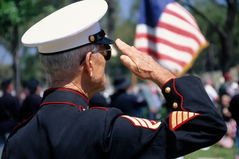 Retired Marine in dress uniform saluting