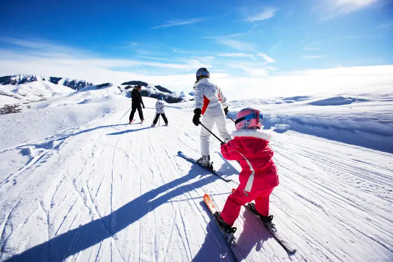 Family skiing, rear view
