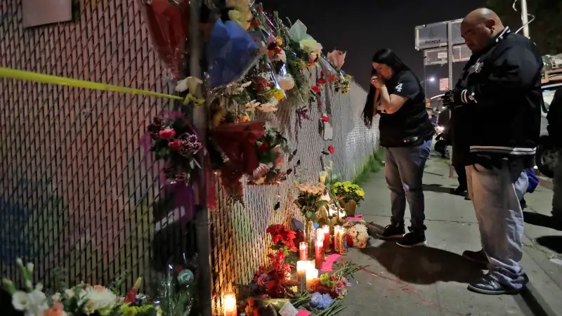 Sol Rodriguez, center, and Aaron Torres visit a shrine for the victims of a warehouse fire near the site Sunday, Dec. 4, 2016, in Oakland, Calif. The death toll was expected to rise, as crews using buckets and shovels slowly made their way through the building, finding victims where they least expected them, Alameda County Sheriff's Sgt. Ray Kelly said.