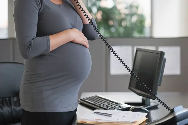 Pregnant woman at desk.