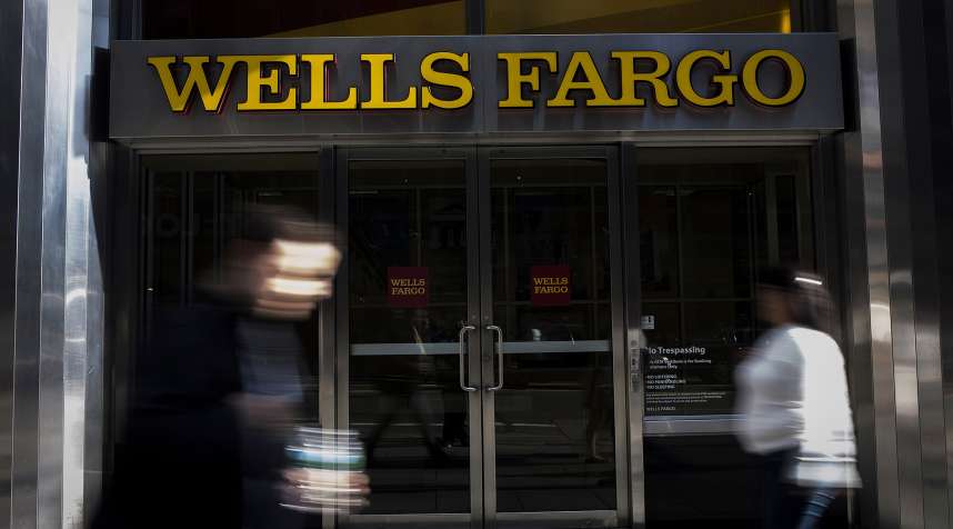 Pedestrians walk past a Wells Fargo &amp; Co. bank branch in New York, U.S., on Thursday, Oct. 6, 2016. Wells Fargo &amp; Co.'s senior executives should be investigated by U.S. prosecutors over the bank's unauthorized creation of customer accounts, Democrats in the U.S. Senate told Attorney General Loretta Lynch.