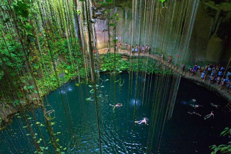 Tourists swimming in Ikil cenote on Yukatan peninsula in Mexico