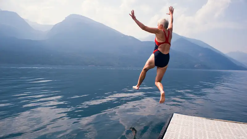 eldery woman jumping lake mountains