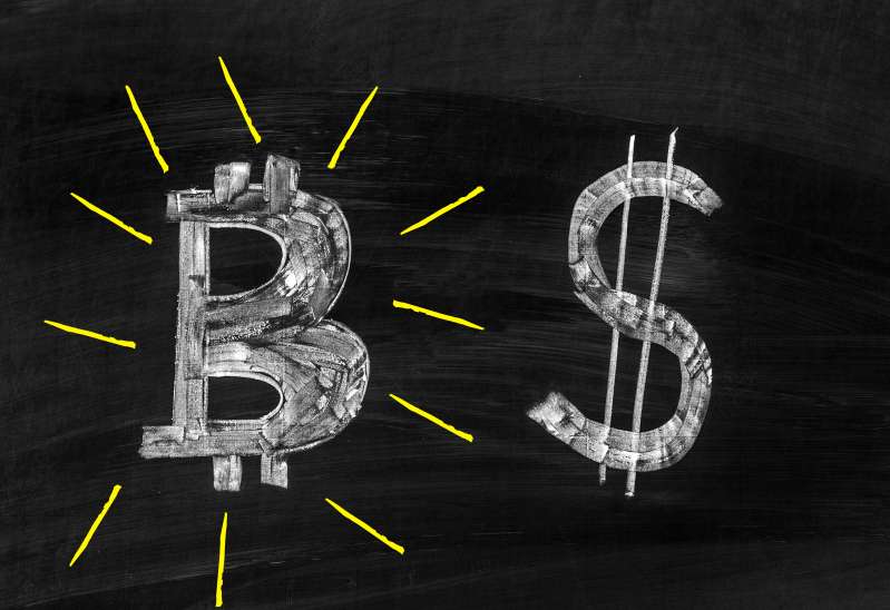Dark chalkboard with a bitcoin and dollar illustration.