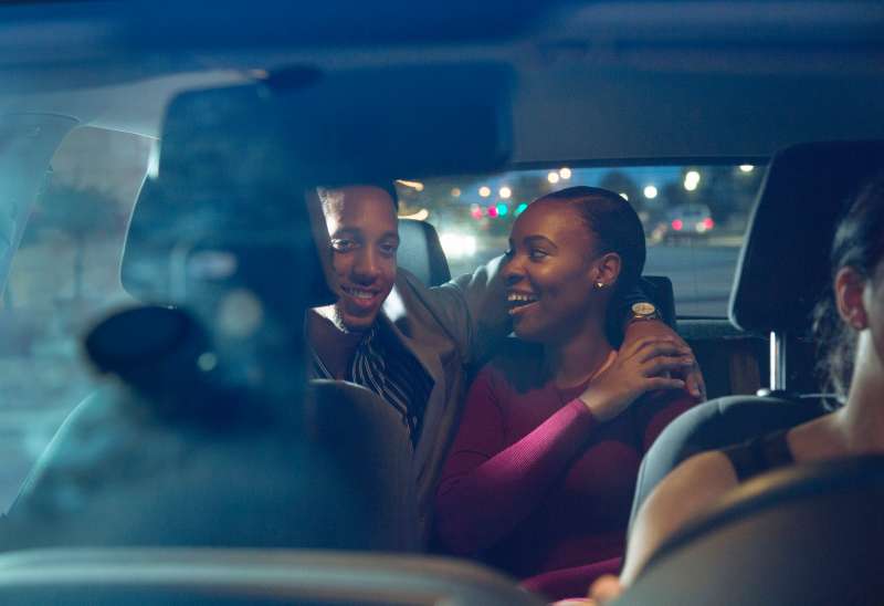 Young couple enjoy a night out using a taxi service