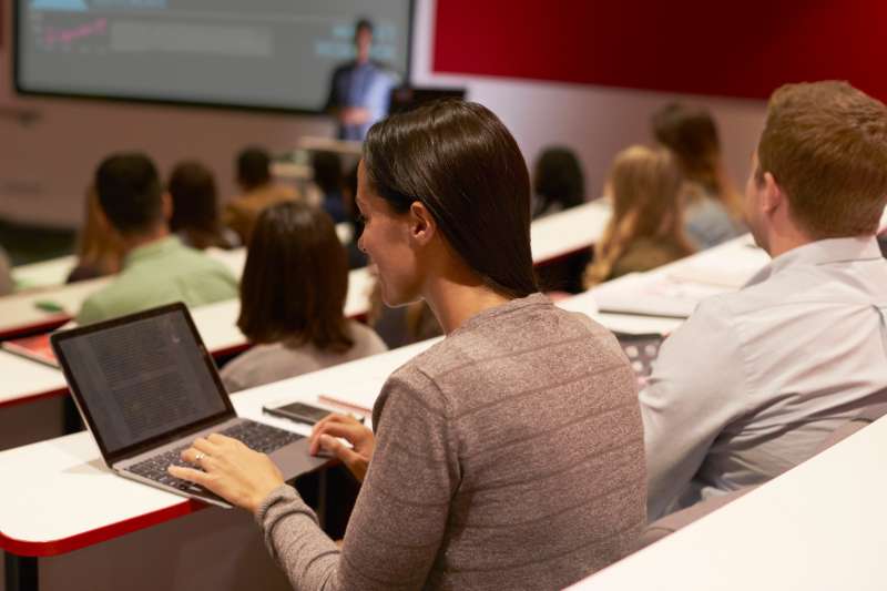 Student using laptop computer at a university lecture.
