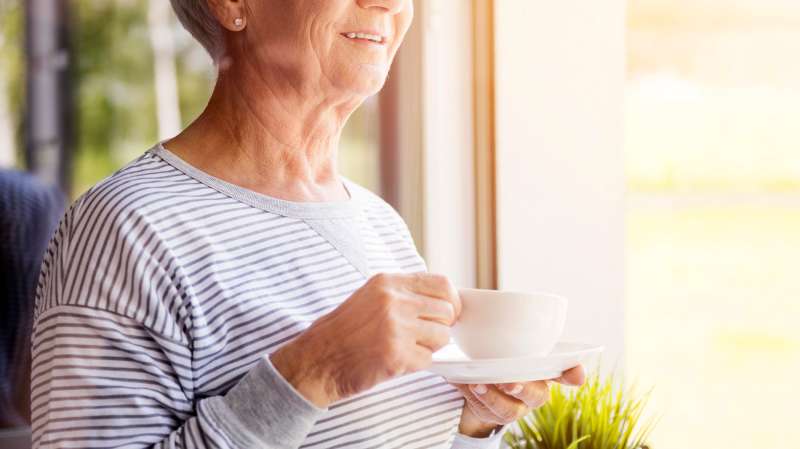 Senior woman holding fresh coffee