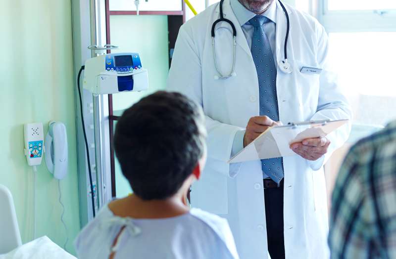 doctor seeing young patient and father