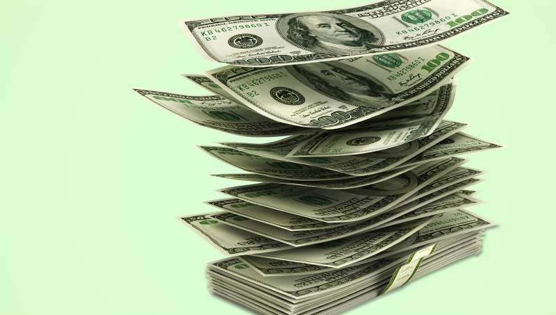 flying dollar bills in stack