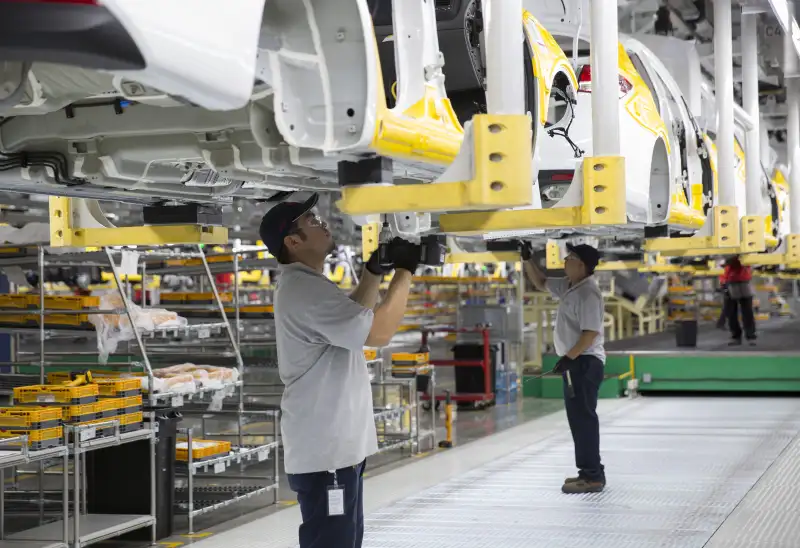 Workers assemble Kia Motors Corp. Forte vehicles