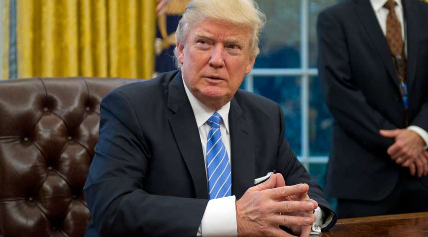 President Donald Trump prepares to sign three Executive Orders in the Oval Office on January 23, 2017.