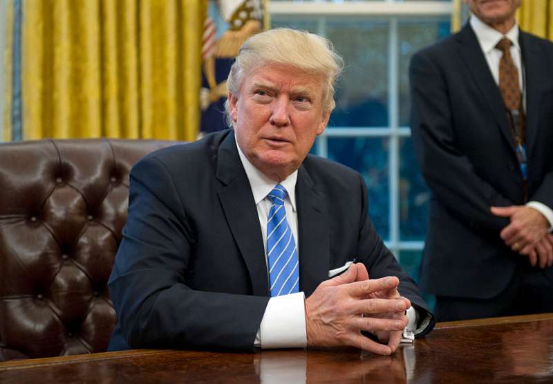U.S. President Donald Trump prepares to sign three Executive Orders in the Oval Office of the White House in Washington, DC on Monday, January 23, 2017.