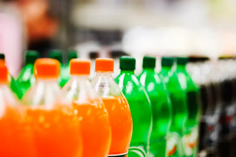 Lots of soda bottles in various flavours all lined up