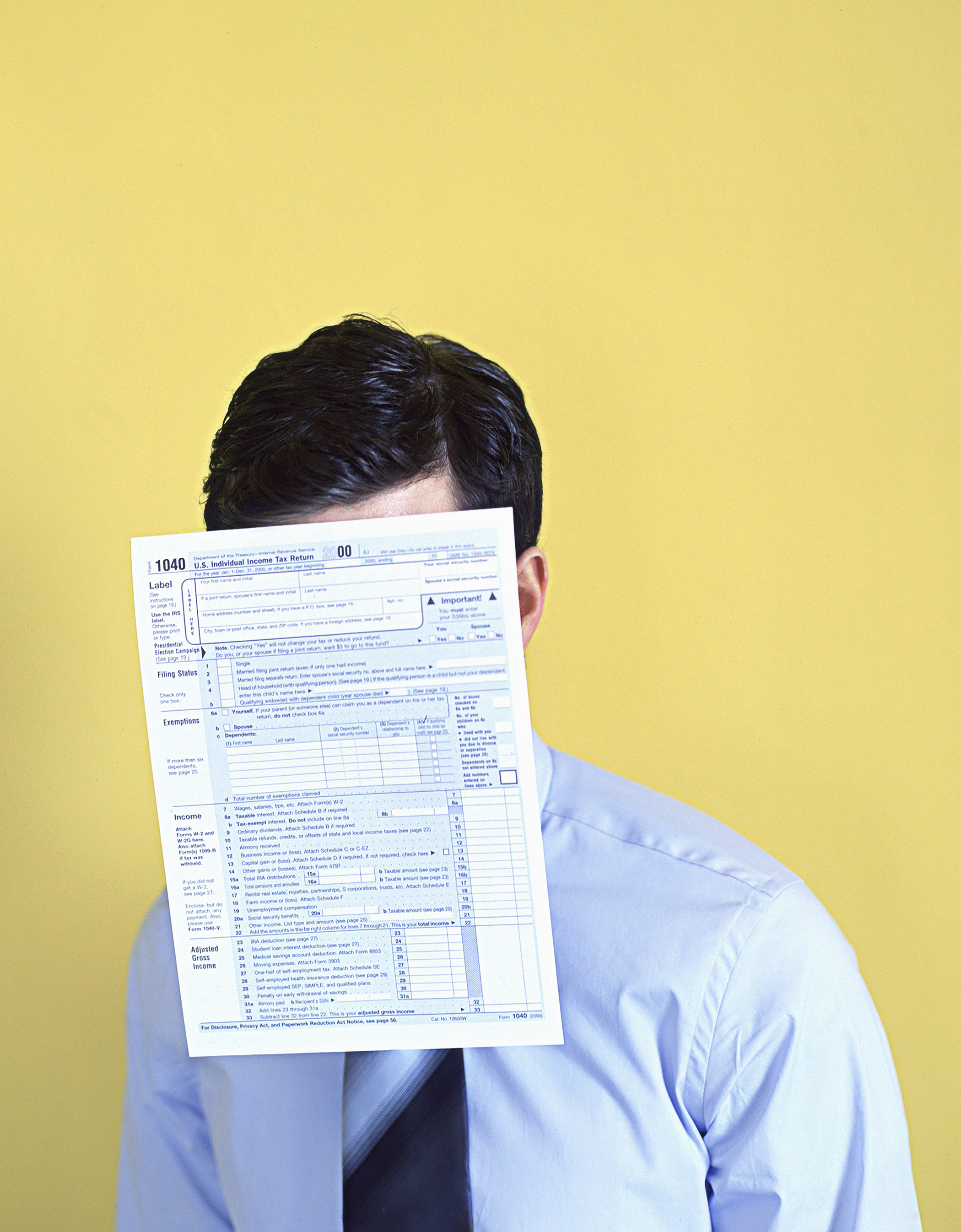 Man With 1040 tax form covering face
