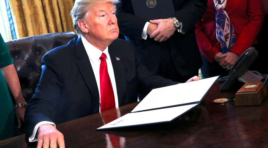 U.S. President Donald Trump signs Executive Orders in the Oval Office of the White House, including an order to review the Dodd-Frank Wall Street to roll back financial regulations of the Obama era February 3, 2017 in Washington, DC.