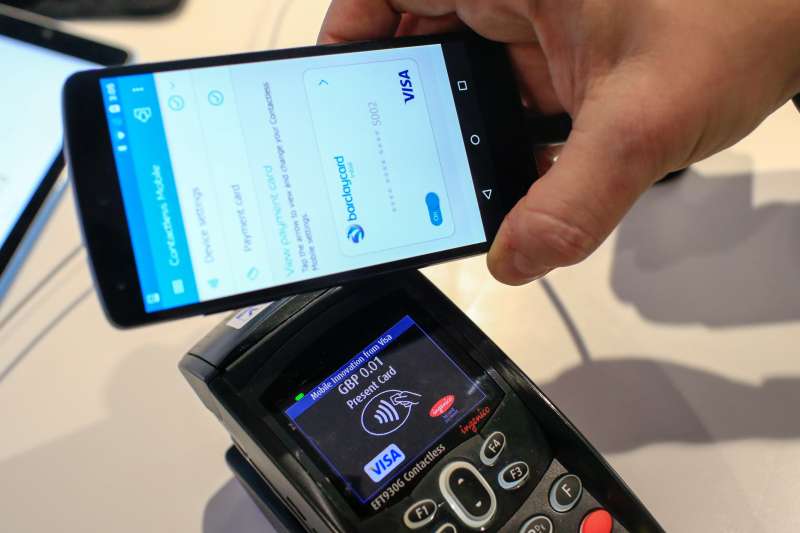 A worker demonstrates a mobile payment system at the Visa Inc. stand at the Mobile World Congress in Barcelona, Spain, on Feb. 22, 2016.