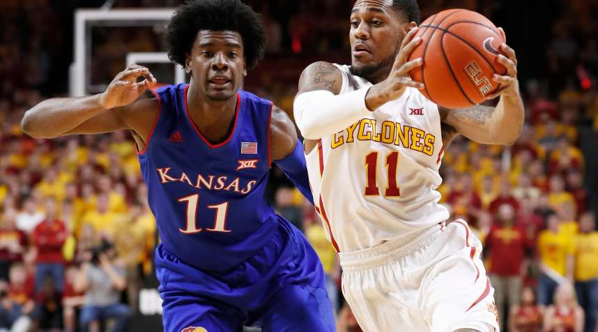 Josh Jackson #11 of the Kansas Jayhawks puts pressure on as Monte Morris #11 of the Iowa State Cyclones drives the ball in the first half of play at Hilton Coliseum on January 16, 2017 in Ames, Iowa.