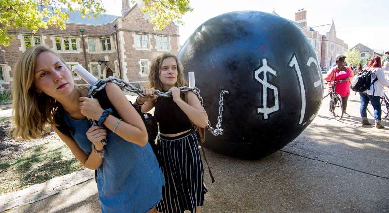 Students pull a mock  ball &amp; chain  representing the $1.4 trilling outstanding student debt at Washington University in St. Louis, Missouri, where second presidential debate will be held between Republican nominee Donald Trump and his Democratic counterpart Hillary Clinton.