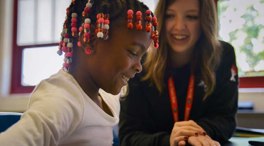 Americorps reading tutor Kelly Meany (left) gives one-on-one reading instructions to  second grader Madissen Moody  on September 19, 2014, in Washington, D.C.