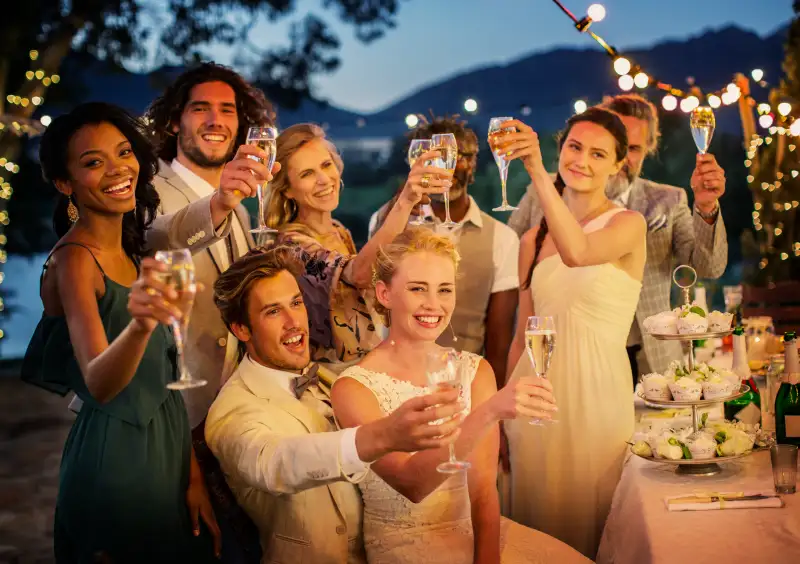 Wedding guests toasting with champagne during wedding reception in garden