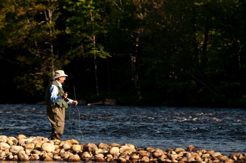 Retired executive fly fishing on a river.