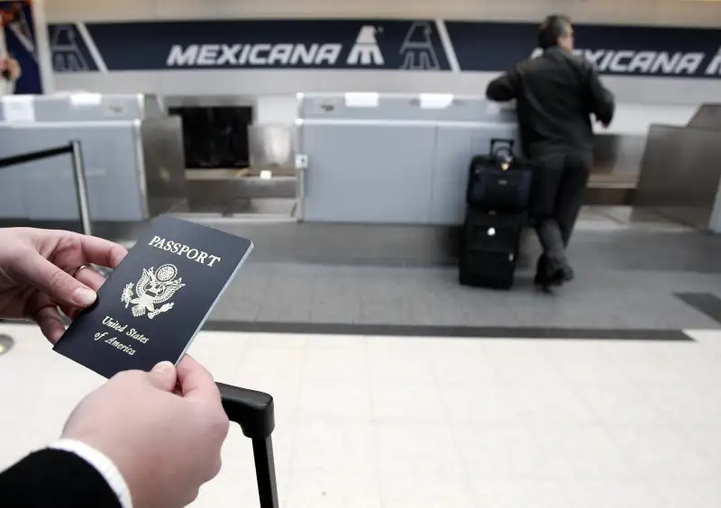 A passenger waits in line with her passp