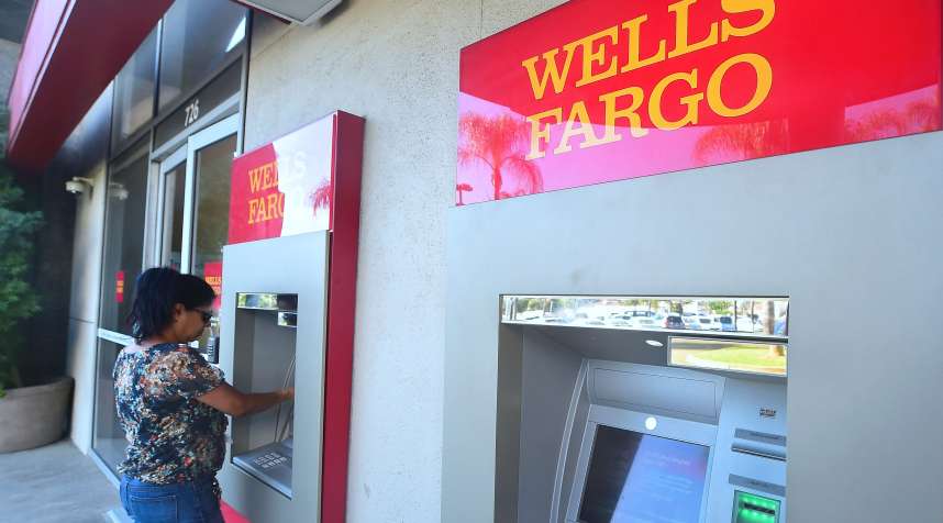 A woman uses an ATM at a branch of Wells Fargo in Alhambra, California on September 28, 2016.