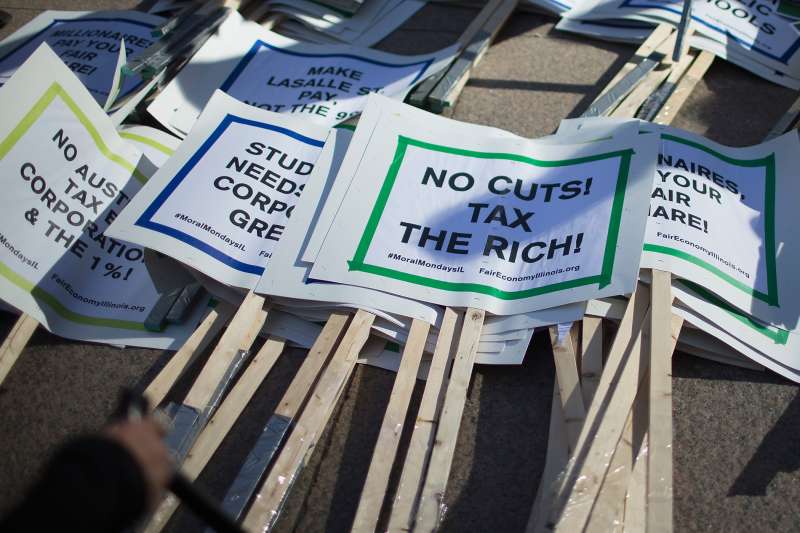 Signs sit in a pile before the start of a protest against the state of Illinois budget stalemate on November 2, 2015 in Chicago, Illinois.