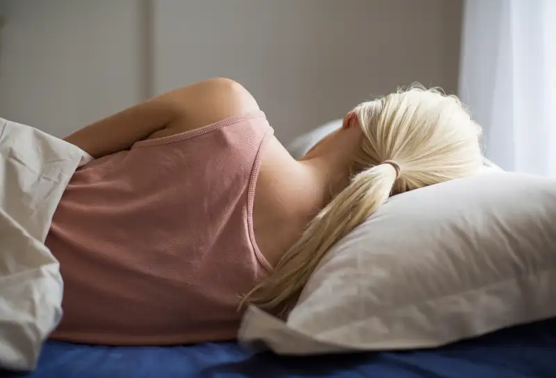 Rear view of woman sleeping in bed