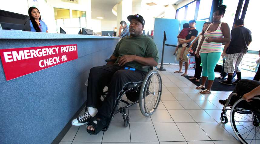 Nikita Hendrix, center (in wheelchair), waits to be treated for a pressure sore on his foot, during a visit to the emergency room at Long Beach Memorial Hospital on August 13, 2014.  In one of the first signs of the effects of Obamacare, most hospitals in Los Angeles County had an increase in visits to their emergency departments in the first part of 2014.