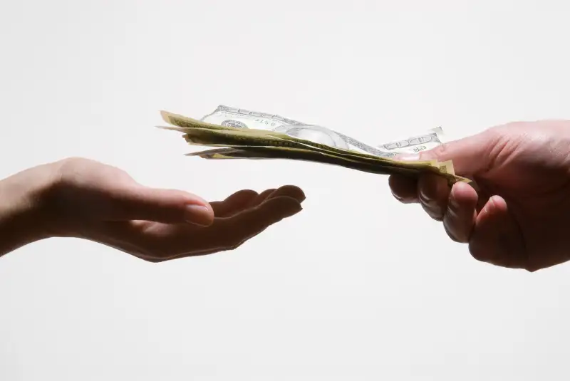 Man handing woman US dollar banknotes, close-up