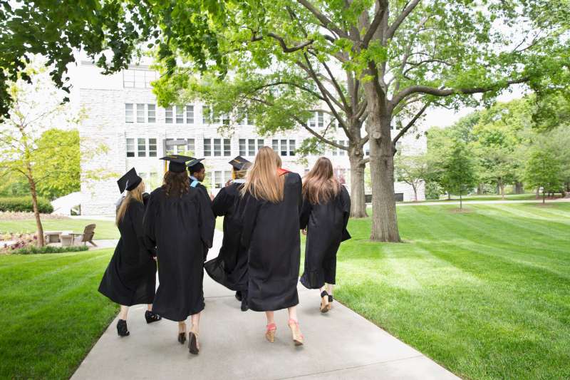 Back view of college graduates walking away
