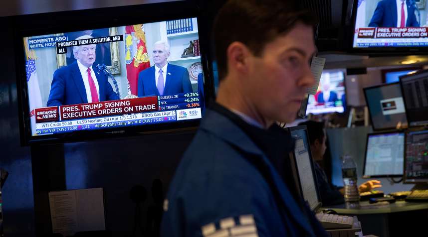President Donald Trump is displayed on television monitors as traders work and financial professionals work on the floor of the New York Stock Exchange (NYSE) ahead of the closing bell, March 31, 2017 in New York City.